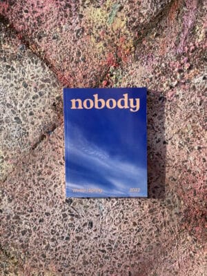 Cover Nobody mit Wolkenhimmel auf Plastersteinen, die in zarten Regenbogen bemalt sind