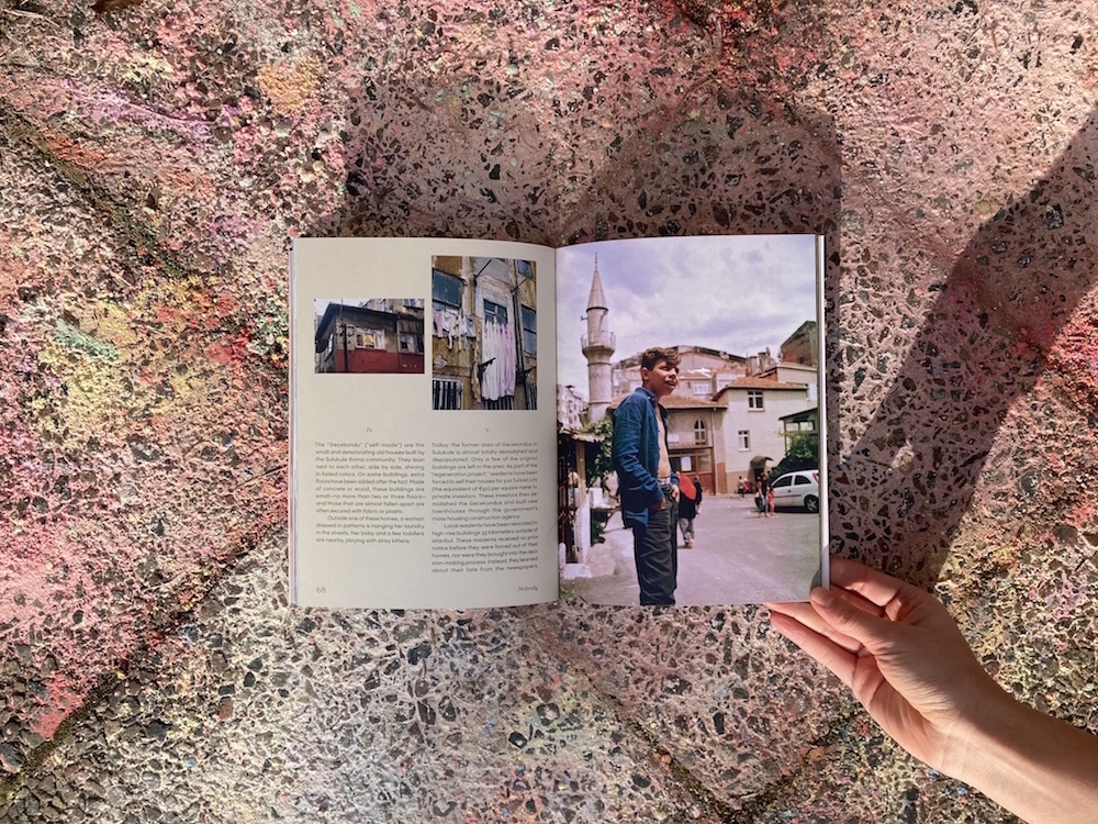 Aufgeschlagenes Nobody Magazin mit jungem Mann vor Moscheeturm auf Plastersteinen, die in zarten Regenbogenfarben bemalt sind