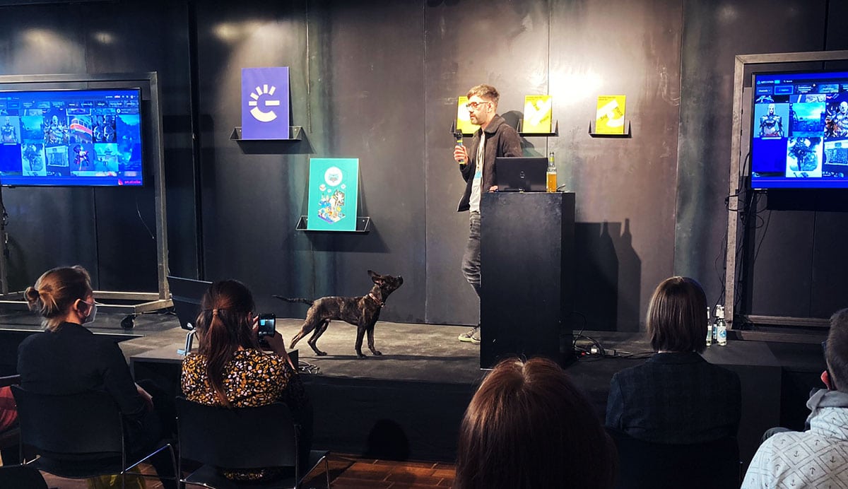 Reiko Groß hält einen Impulsvortrag über die Game Design Branche, sein Hund »Trüffel« leistet ihm auf der Bühne Gesellschaft