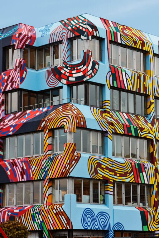 Mit bunten Wax-Print-Mustern überzogene Hausfassade des Stoffherstellers Vlisco, gestaltet von Simone Post, vier etagen sieht man