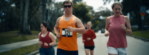 Chris Kikic, adidas gesponserter Sportler mit Downsyndrom läuft mit anderen eine Straße entlang und man sieht seine Marathon-Startnummer 321