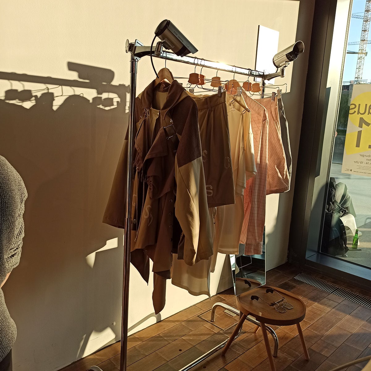 An einer Kleiderstange hängen mehrere Modedesigns in der Sonne