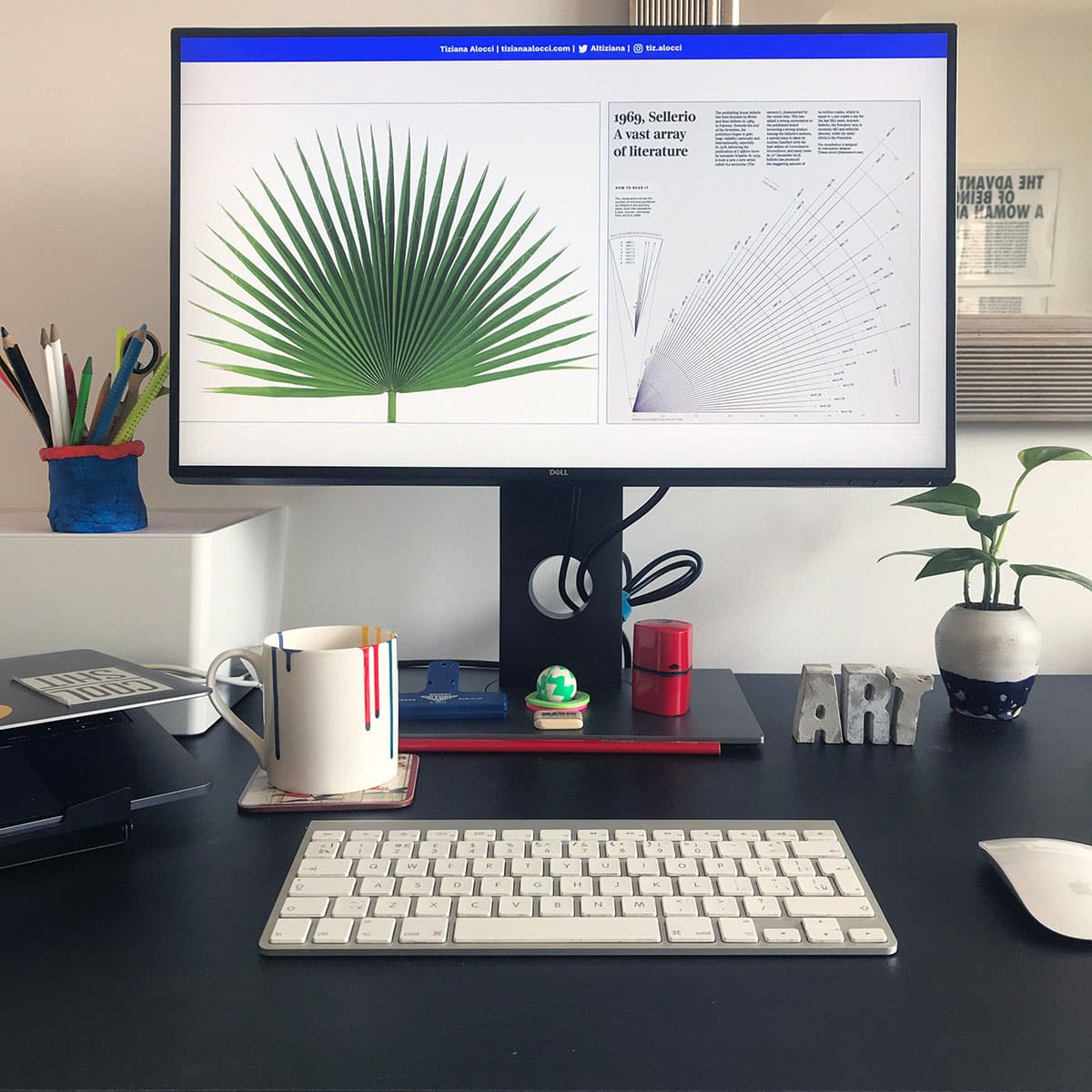 Tiziana Aloccis Schreibtisch mit einem großen Bildschirm und einer kaffeetasse