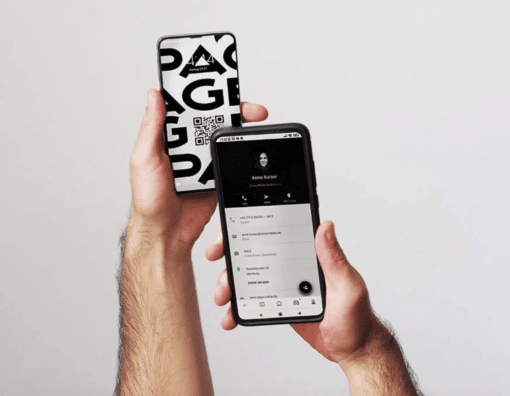 Eine Hand scannt mit dem Handy einen QR-Code mit digitaler Visitenkarte v on einem anderen Handy ab