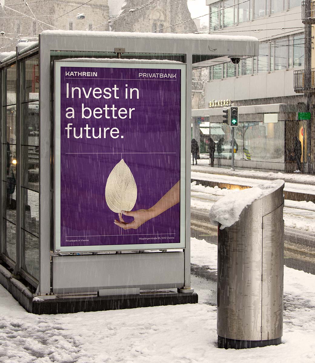 ein Plakat hängt an einer verschneiten Bushaltestelle. darauf hält eine hand ein weißes Blatt für Nachhaltigkeit