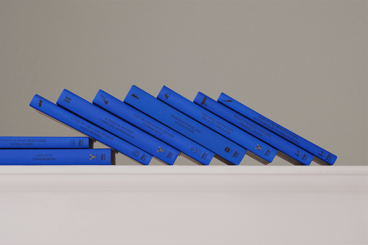 Eine Buchreihe mit blauen rücken liegt schräg nebeneinander in einem regal