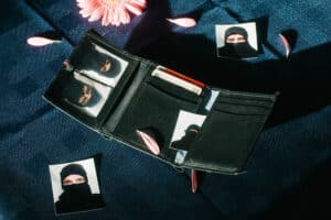 Portraitbild von Seriff’s Department, auf dem eine aufgeklappte Geldbörse mit 5 verschiedenen Passfotos zu sehen ist. Die abgebildeten Personen tragen alle eine schwarze Sturmhaube.