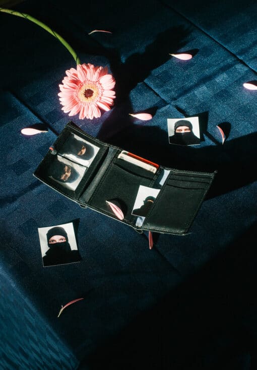 Portraitbild von Seriff’s Department, auf dem eine aufgeklappte Geldbörse mit 5 verschiedenen Passfotos zu sehen ist. Die abgebildeten Personen tragen alle eine schwarze Sturmhaube.