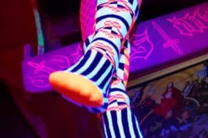 Zwei übereinandergeschlagene Füße mit orange leuchtenden Socken