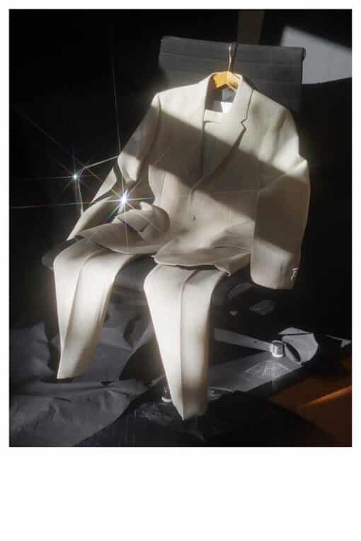 Ein weißer Anzug liegt über einen Plastikstuhl drapiert