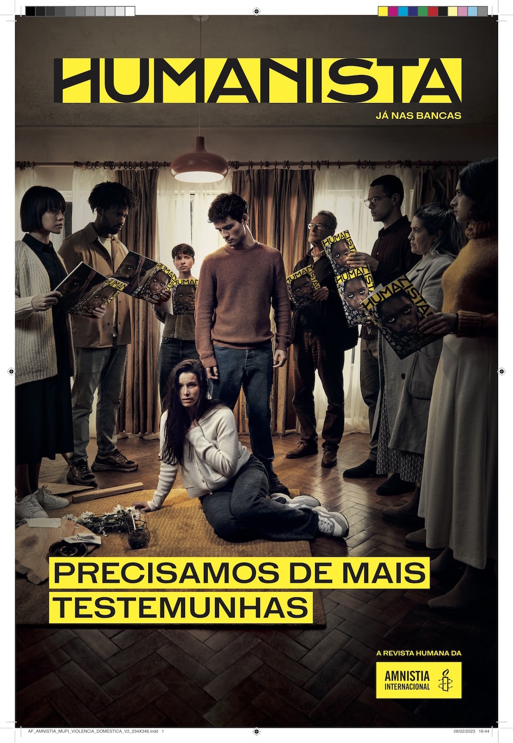 Kampagne für das neue Amnesty International Magazin Humanista: Auf dem Boden in einem Zuhause sitzt eine weibliche Person, die sich den Hals hält. Hinter ihr steht ein Mann, der auf sie herabschaut. Drum herum stehen mehrere Personen und lesen das neue Humanista-Magazin. 
