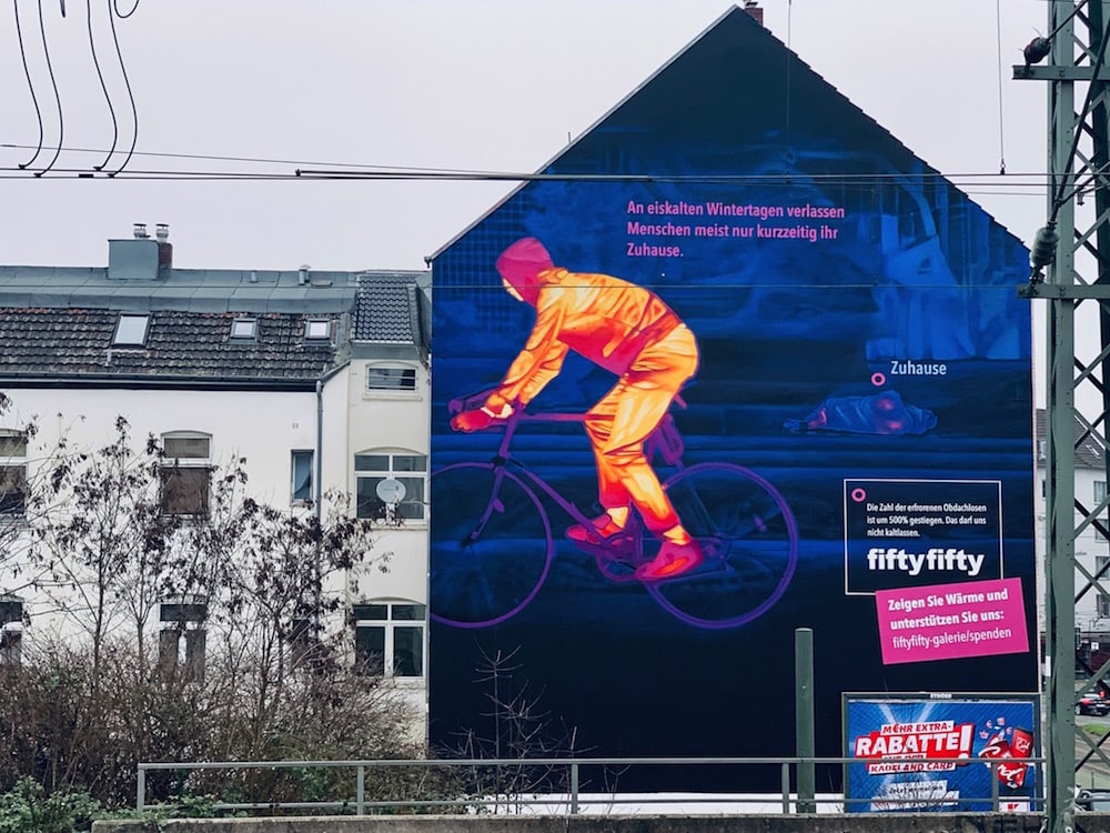 Kampagne »Winter in Deutschland« von fiftyfifty. Hauswand mit Wärmebild, tagsüber (Fahrradfahrer:in)
