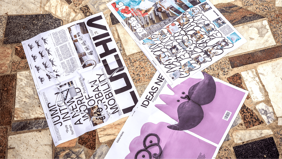 Eine Draufsicht auf drei Bögen der Agenturzeitung, die unterschiedliche typografische Designs zeigen