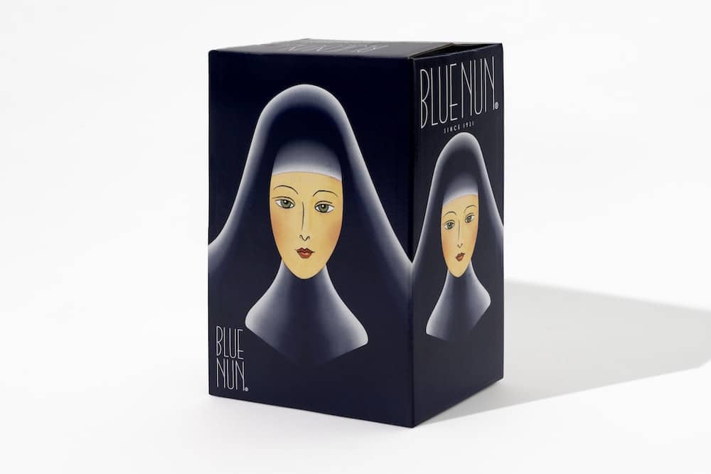 Packaging Design: Weinkarton der Marke »Blue Nun« für sechs Flaschen. Der Karton ist schwarz mit der Illustration einer Nonne in blauem Gewand auf allen Seiten. 
