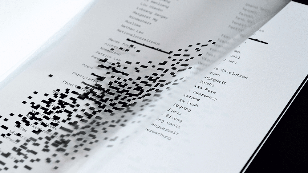 Pixel-Schrift Index Mono: Auf einer Folie sind schwarze Pixel zu sehen, die den drunterliegenden Text teilweise verdecken