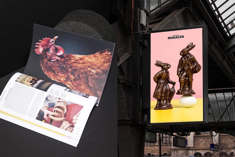 Blick ins neue Schweizer Bauer Magazin auf der linken Seite. Rechts ein Werbeplakat für das Magazin mit einem menschlichen Hasenpaar, von dem ein Hase auf einem Ei balanciert