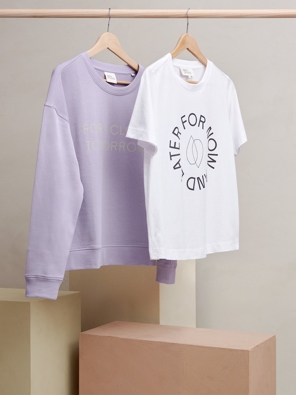 Studio Oeding gestaltet NAH/STUDIO: Fliederfarbener Pullover und weißes T-Shirt auf einer Kleiderstange
