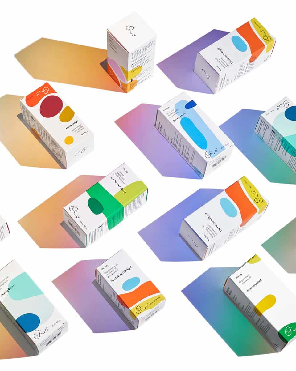 Eine reihe an Produkten mit weißer Papierpackung, auf die bunte Farbflächen und Kleckse gedruckt sind, die einander überlagern