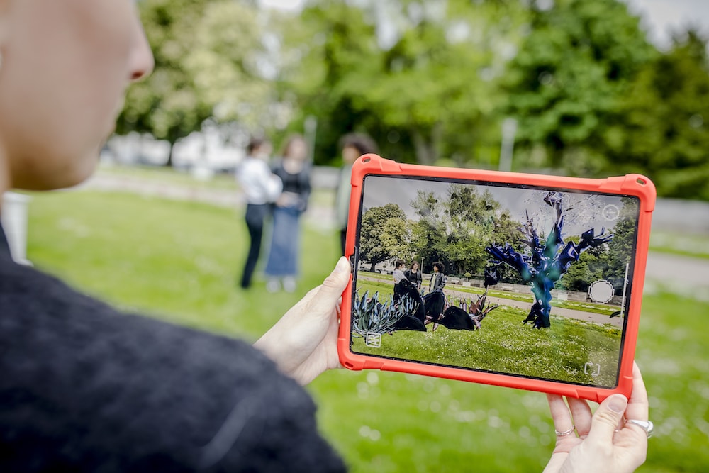 Augmented Reality Biennale in Düsseldorf mit AR Landschaft, die sich Besucher auf iPad anschaut