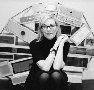 Debbie Millman sitzt in einem schwarzen Rollkragenpullover vor einer Konstruktion aus mehreren Schubladen