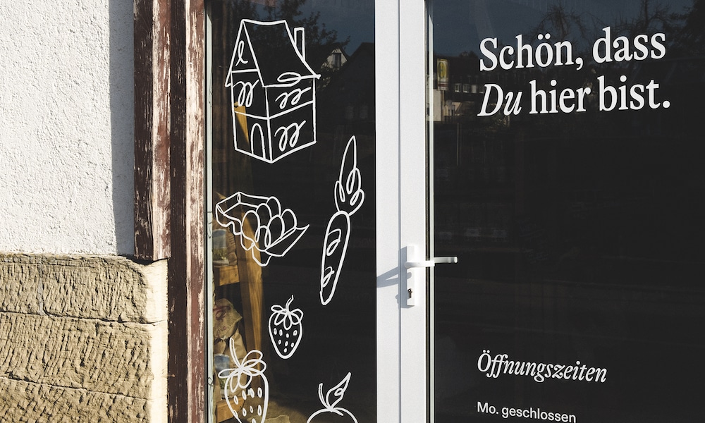 Neue Identity für den traditionellen Bauernhof und Laden Micheleshof: Ttür mit Illustrationen Haus, Karotten, Eier, Brot