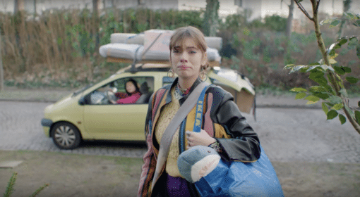 Still aus Ikea-Werbespot von thjnk: Junge Frau mit gepackten Sachen und traurigem Gesichtsausdruck, im Hintergrund beladenes Auto und Fahrerin