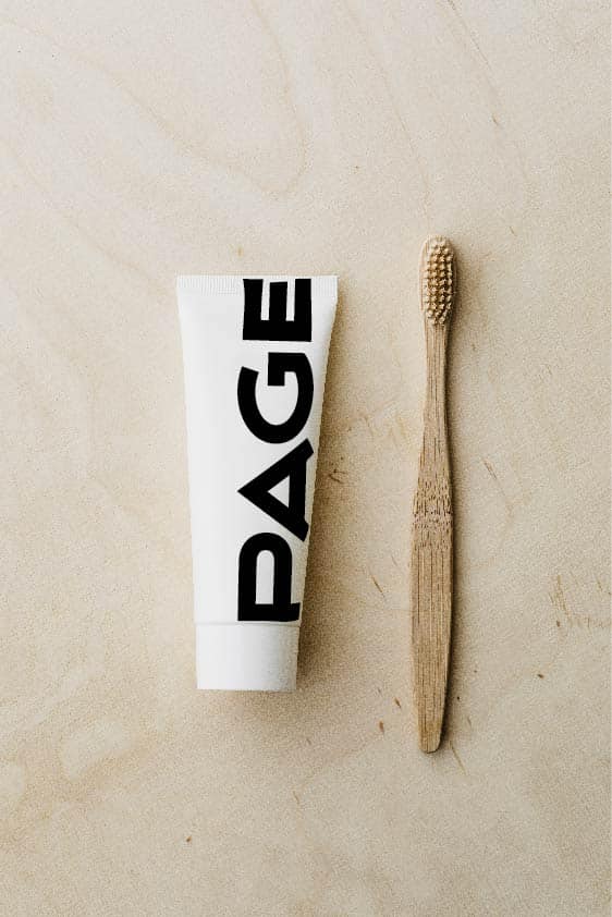 eine zahnpastatube neben einer Holzbürste, auf der das page logo steht