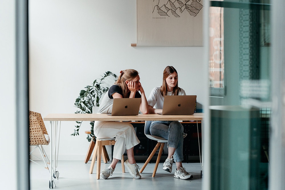 Foto aus den Räumlichkeiten der Agentur Sherpa Design: Zwei Kolleginnen bei der Arbeit