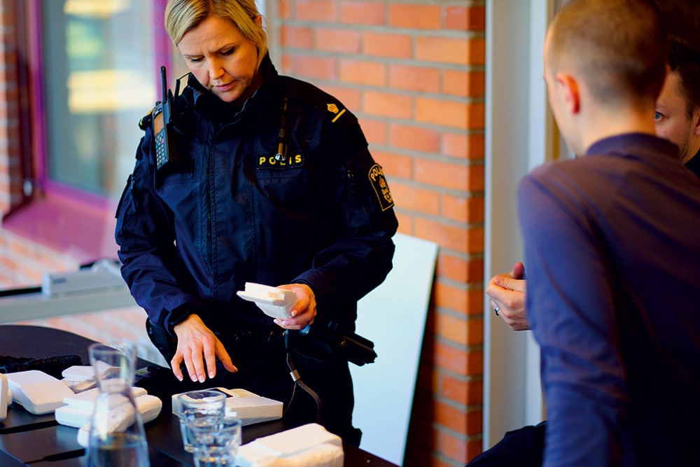 Polizistin schaut sich die Prototypen des mobilen Drogentestgeräts Substanz:ID an