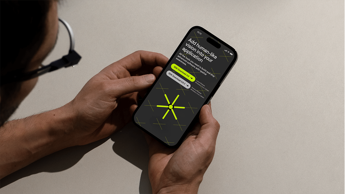 zwei Hände halten ein Handy mit einer app, die ein dreidimensionales sternförmiges Icon auf dunklem Grund zeigt