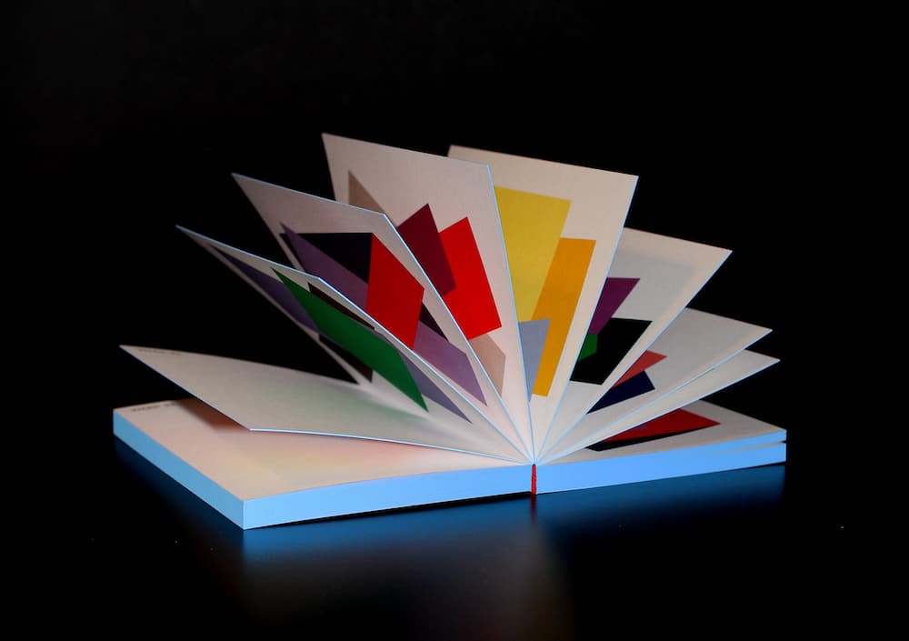 Wie ein Fächer geöffneter Color Kombination Kalender 2024 von Luzia Hein. Man sieht die bunten Farbkombinationen auf den einzelnen Seiten.