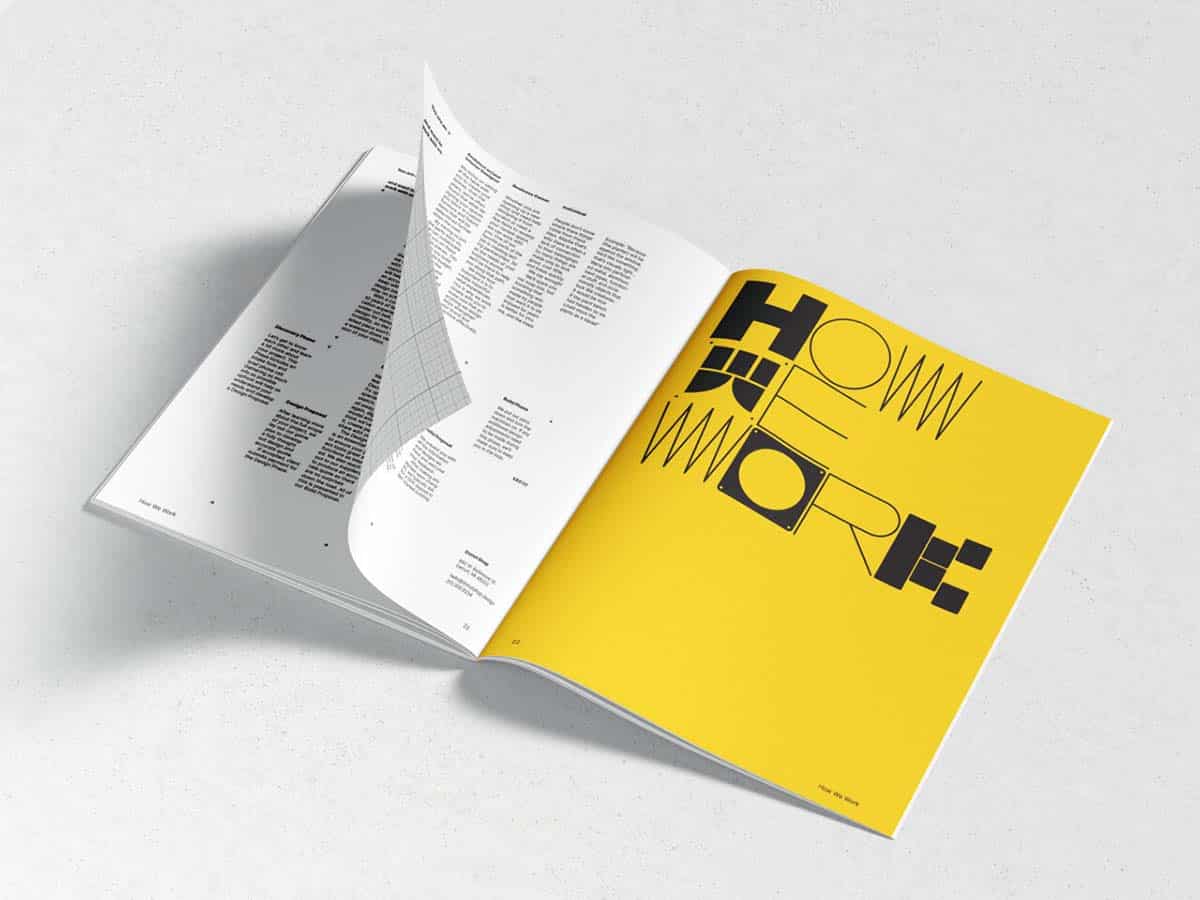 Eine aufgeschlagene Zeitschrift auf einer hellen Oberfläche, mit einer gelben Doppelseite, auf der in großen schwarzen Buchstaben 'HOME WORK' steht und Text auf den angrenzenden weißen Seiten.