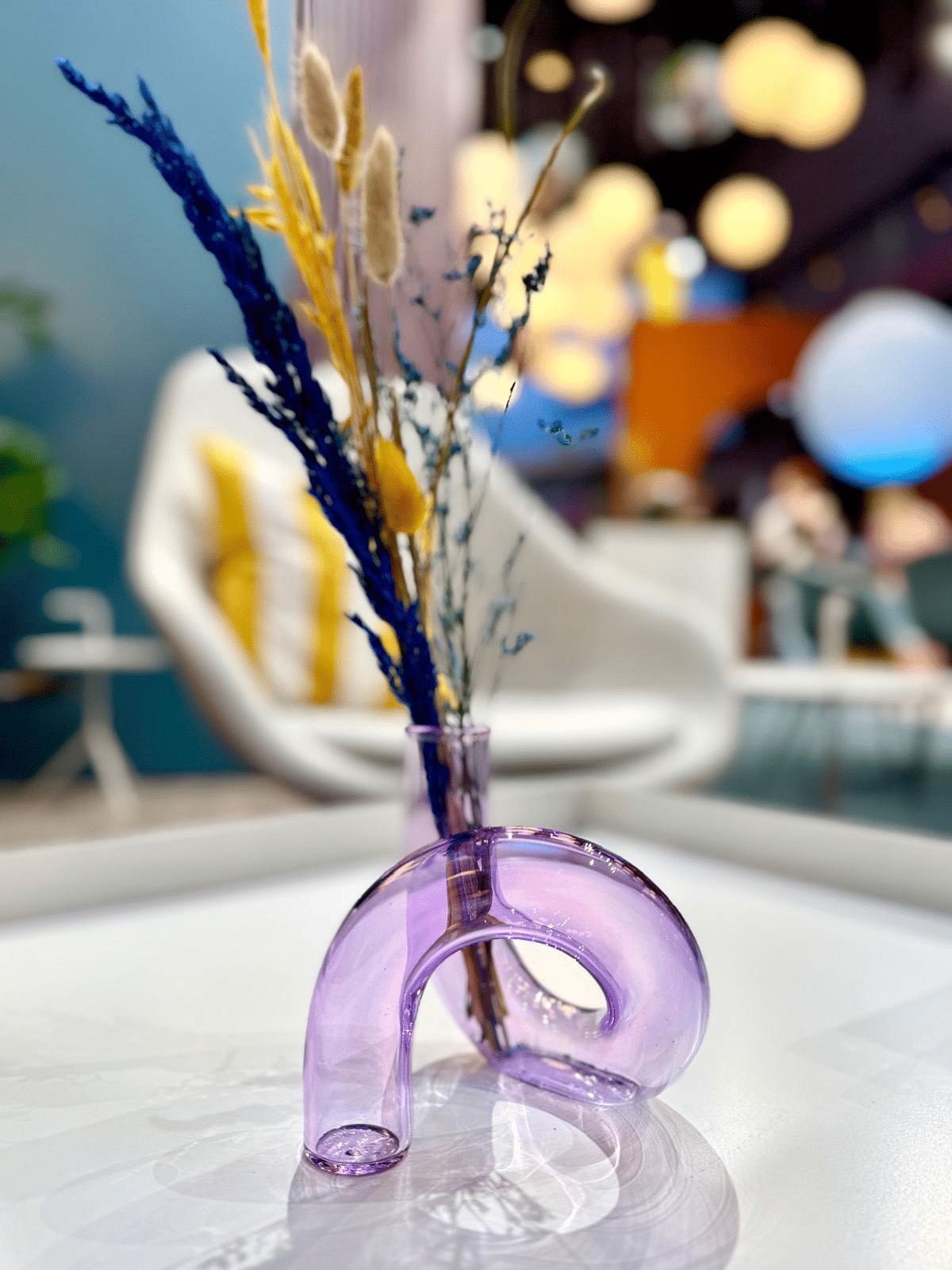 Nahaufnahme von Glasgefäßen mit Trockenblumen und Bastelmaterialien auf einem dunkelgrünen Tisch bei einer Messe