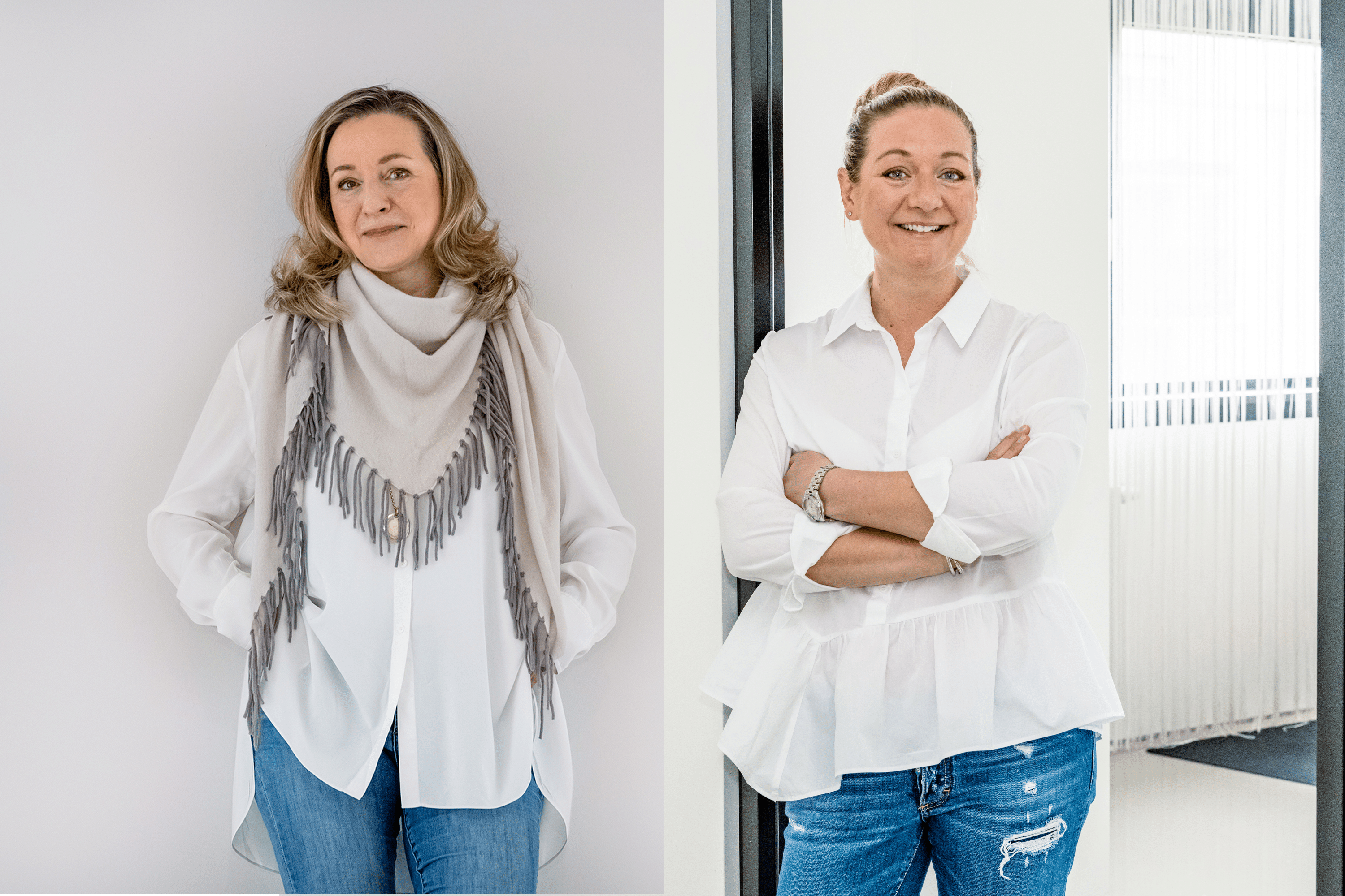 Sabine Kraus steht vor einer weißen Wand, trägt ein weißes Hemd, eine graue Fransenschal und blaue Jeans, lächelnd in die Kamera. Katharina Kraus steht vor einem Bürohintergrund, trägt ein weißes Hemd und blaue Jeans mit verschränkten Armen, lächelnd in die Kamera.