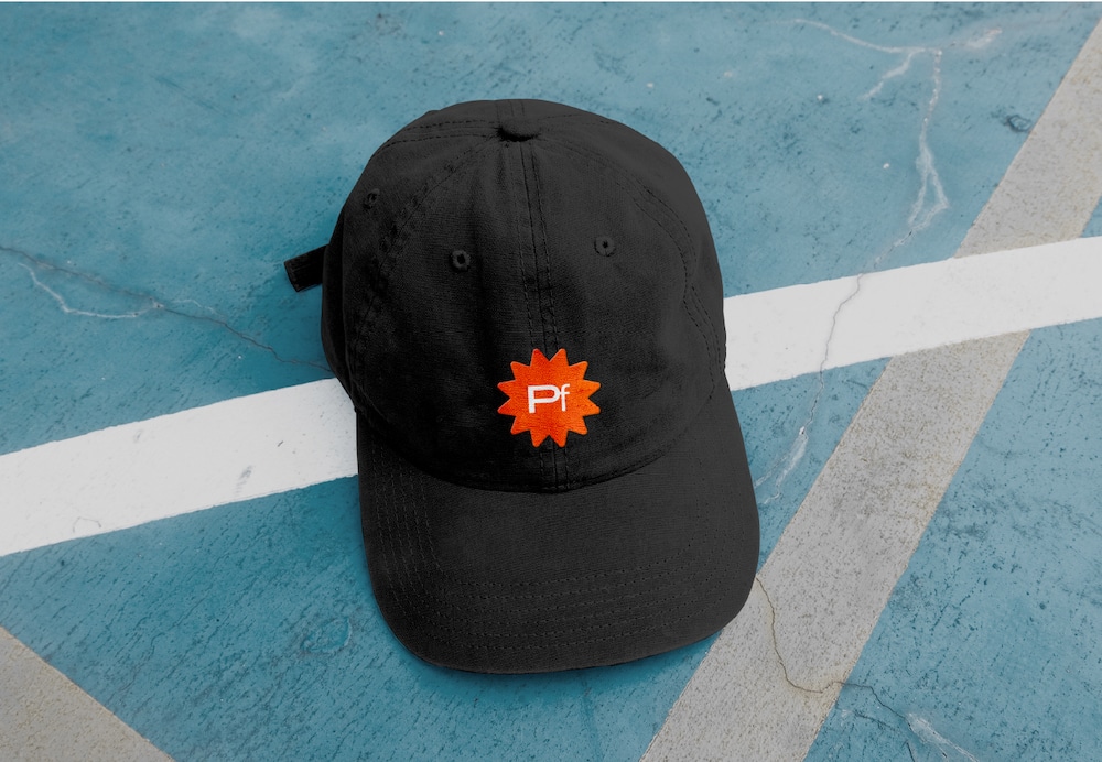 schwarze Cap mit dem Logo des Hamburger Kunst- und Kulturfestival PHŒNIX, Pf auf rotem Stern