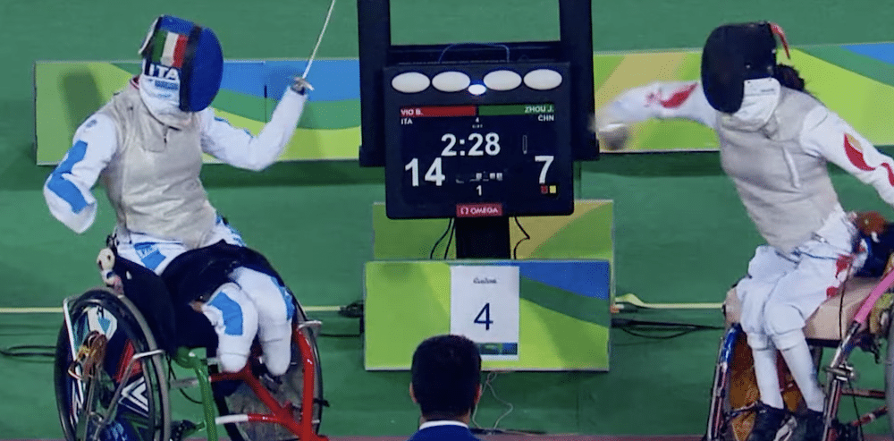 Paralympics-Spot von Nike, Person mit Narben im Gesicht vor blauem Hintergrund, Standbild aus Wettkampf im Rollstuhlfechten, THOU J CHN
VIO B 14
2:28 22280 1 COMEOA
