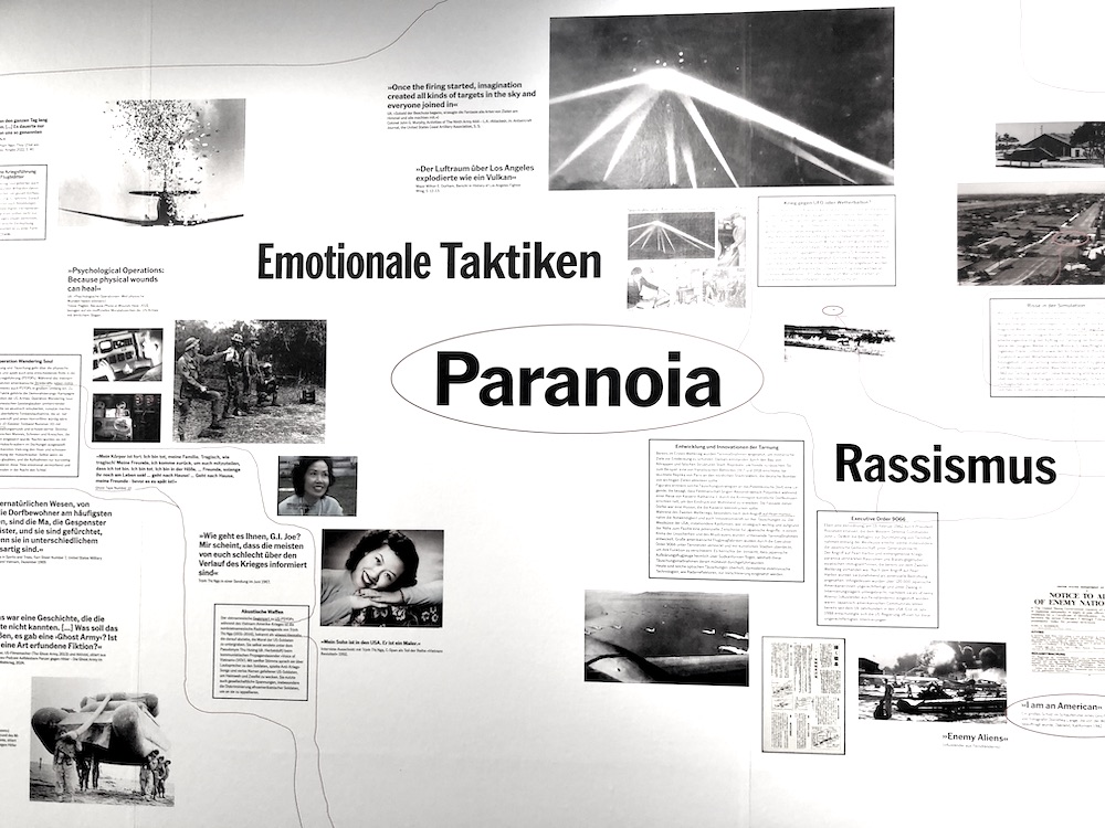 Infografikwand über emotionale Desinformationstaktiken wie Paranoia, Fotos und Schrift 