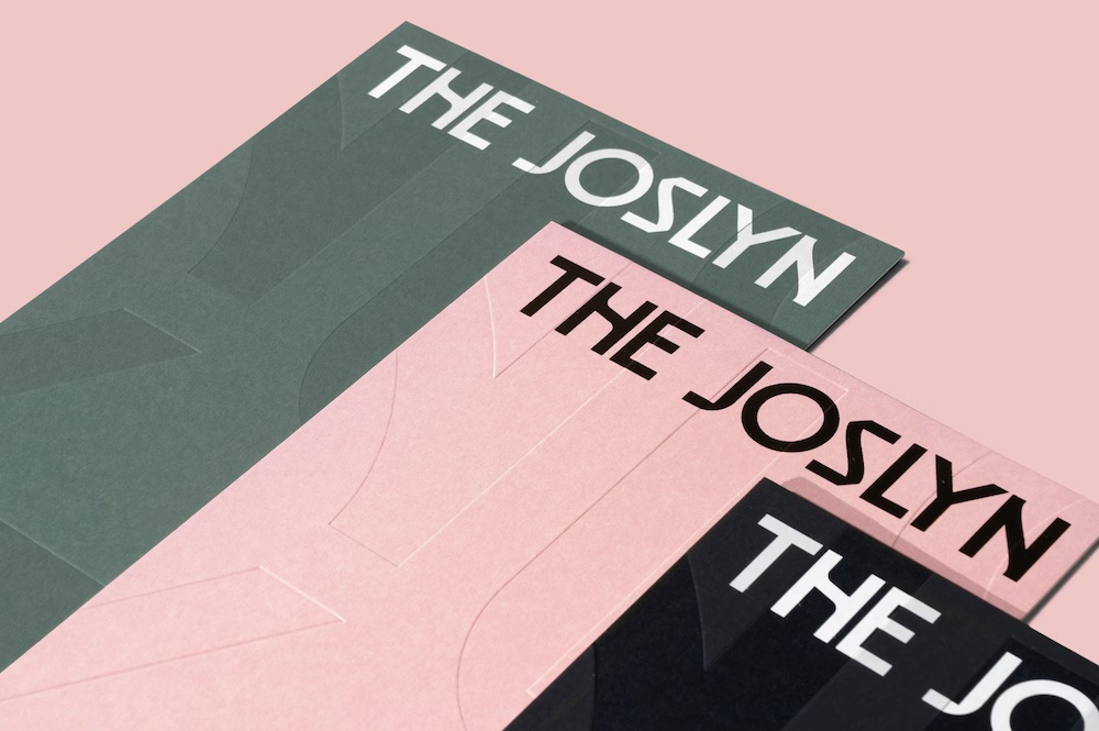 The Joslyn Schriftzug auf drei Broschüren in Grün, Rosa und Schwarz