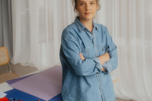 STUDIO B’HAUS, Porträtfoto Ulrike Bruchhaus, Frau in Jeansensemble vor Basteltisch