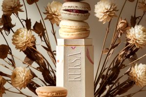 Ein Bild für eine fiktive Kampagne mit einem Packaging für Macarons und Trockenblumen im Hintergrund