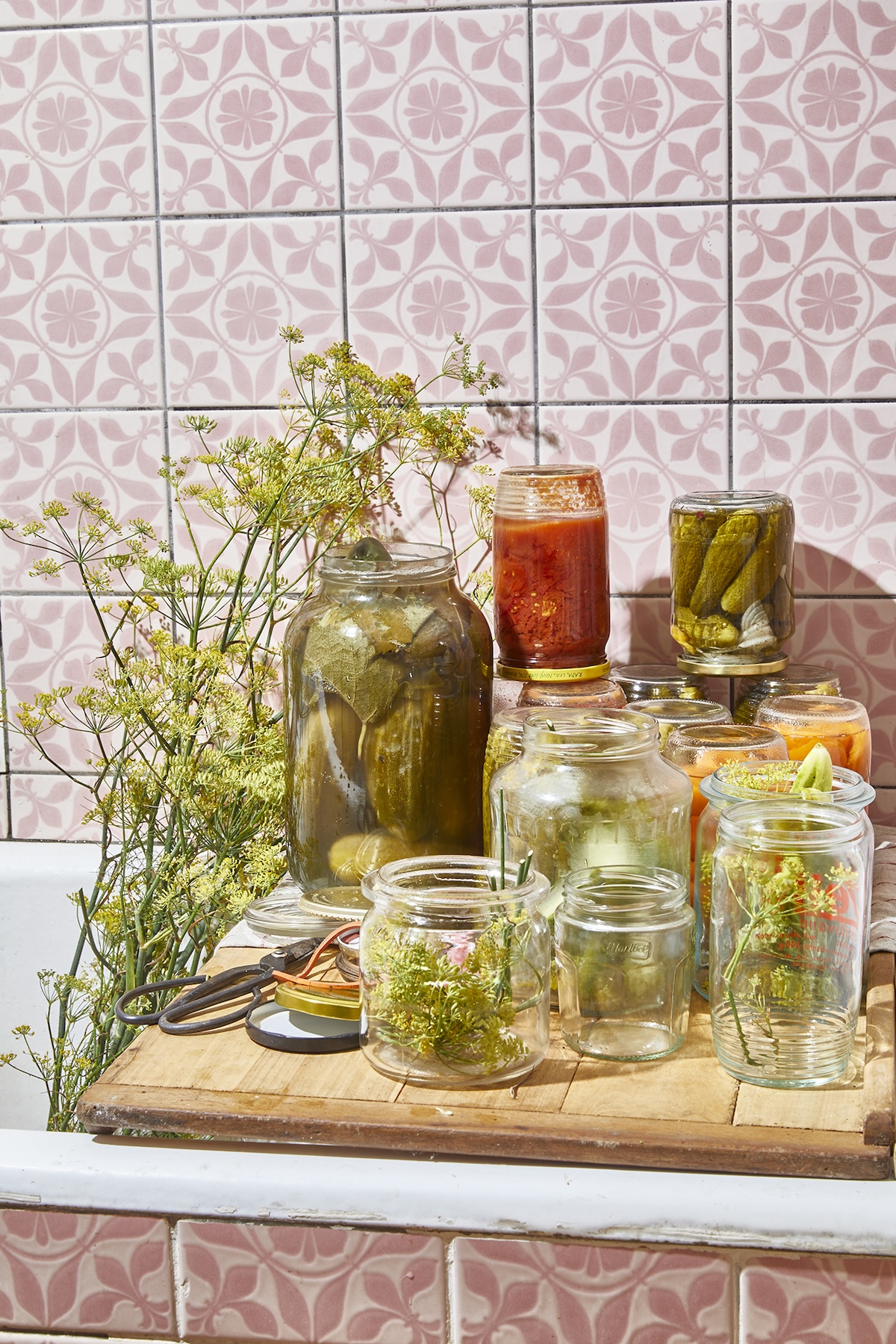 Einmachgläser in Badezimmer mit üppigem Bohnenkraut daneben