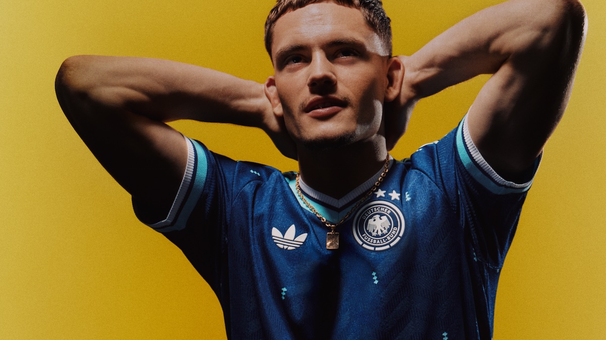 Fußballer im blauen neuen Auswärtstrikot der deutschen Fußballnationalmannschaft vor senfgelber Wand