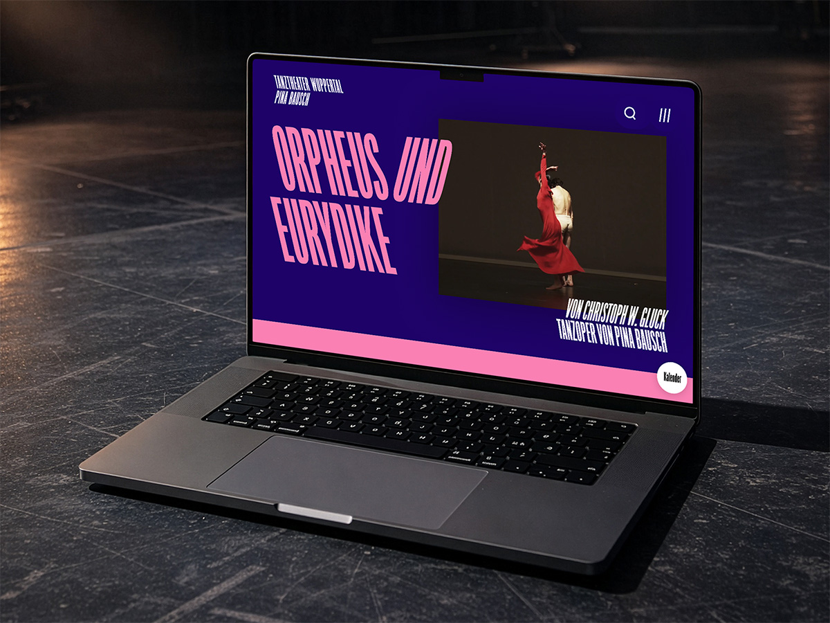 Website-Mockup des Tanztheater Wuppertal Pina Bausch, dargestellt auf einem Laptop auf einem dunklen Bühnenboden. Der Bildschirm zeigt die Produktionsseite zur Tanzoper »Orpheus und Eurydike« von Christoph W. Gluck in Pina Bauschs Choreografie. Der Titel ist in großer, pinker Schrift auf violettem Hintergrund gesetzt, daneben ein Bühnenphoto einer Tänzerin im roten Kleid.