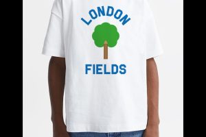Junge mit weißem Shirt mit Baum darauf dessen Stamm ein Bleistift ist und drumherum der Name London Fields steht