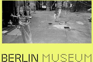 Plakat für Berlin Museum, knallgelber Hintergrund, oben schwarzweiß Fotografie mit Mädchen im Hinterhof, spielen, sind verkleidet und es hängen Girlanden und Luftschlangen herunter, unten Schriftzug Berlin Museum