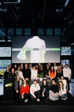 Speaker und Team auf einer Bühne, im Hintergrund großer Screen