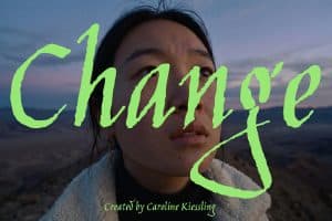 Nahaufnahme einer jungen Frau vor einer weiten, kargen Landschaft in der Abenddämmerung. Über ihrem Gesicht liegt der großflächige, leuchtend grüne Schriftzug „Change“ in expressiver Handschrift. Am unteren Bildrand steht „Created by Caroline Kiessling“.