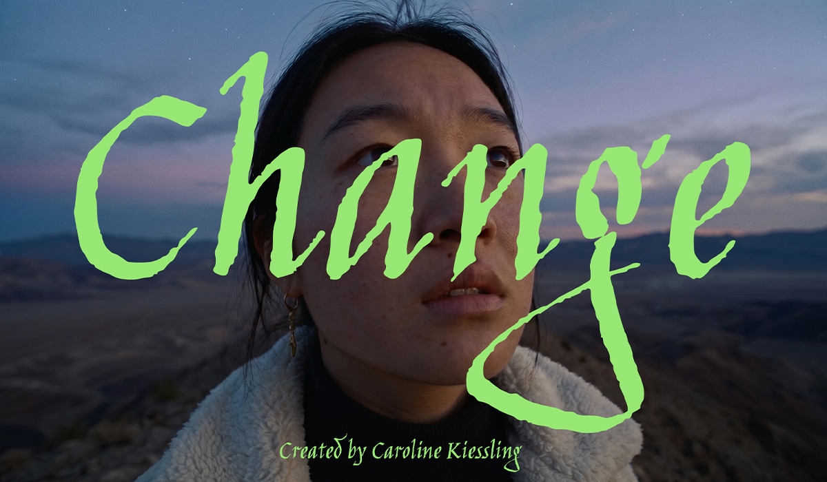 Nahaufnahme einer jungen Frau vor einer weiten, kargen Landschaft in der Abenddämmerung. Über ihrem Gesicht liegt der großflächige, leuchtend grüne Schriftzug „Change“ in expressiver Handschrift. Am unteren Bildrand steht „Created by Caroline Kiessling“.